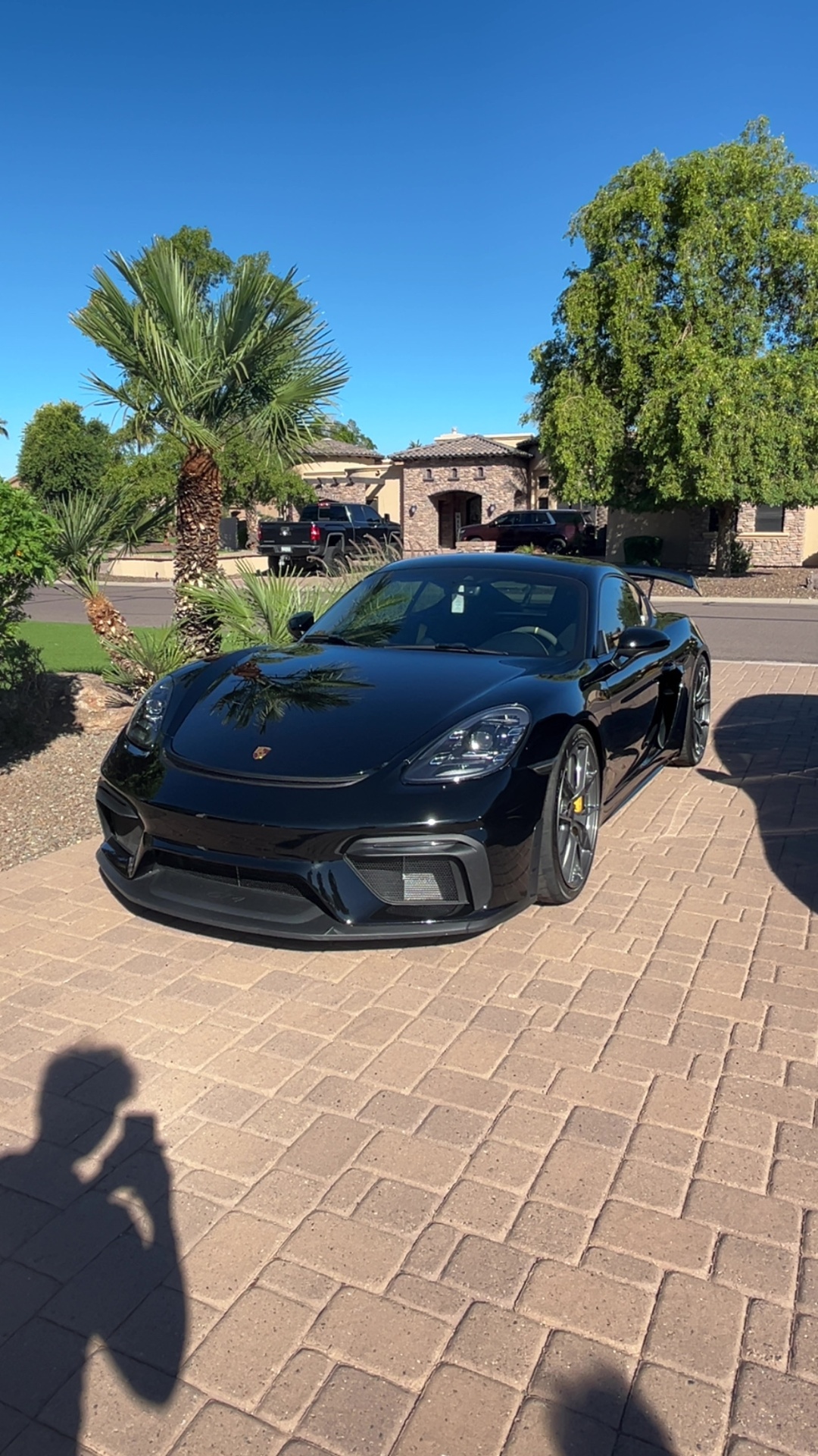 Black Porsche 718 Cayman GT4 detailed in driveway